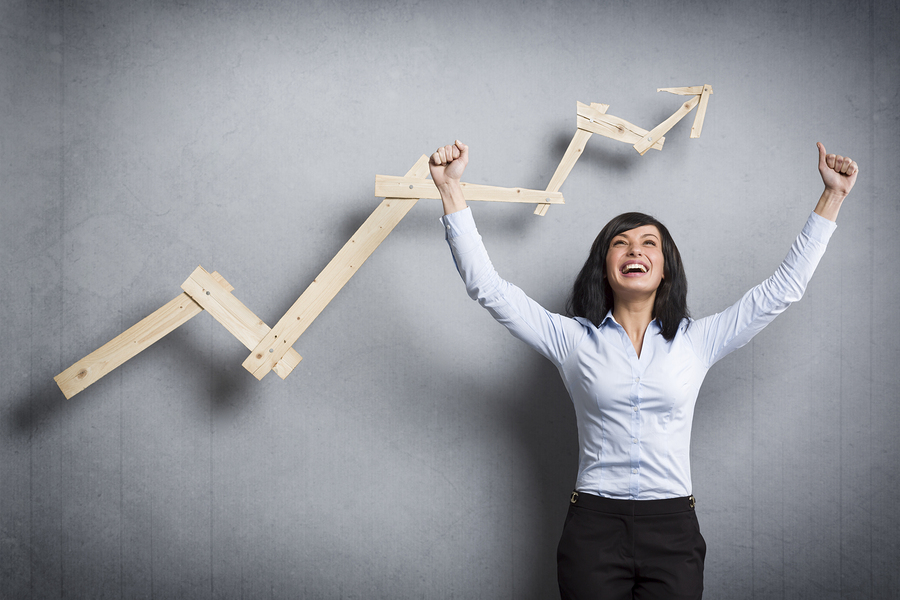 Woman standing behind chart with rising arrow.