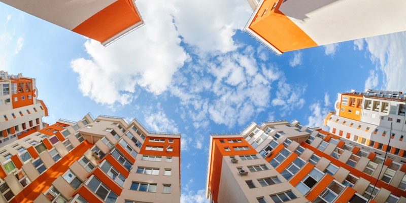 A worm's-eye view of an apartment complex and the sky above it