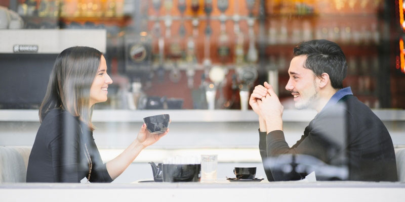 A happy couple drinking coffee in a cafe