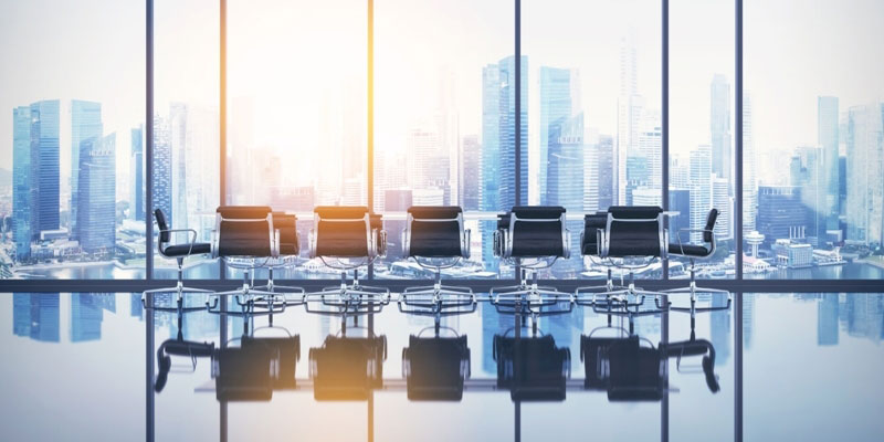 An office conference room with a big glass window through which a city's downtown area is visible