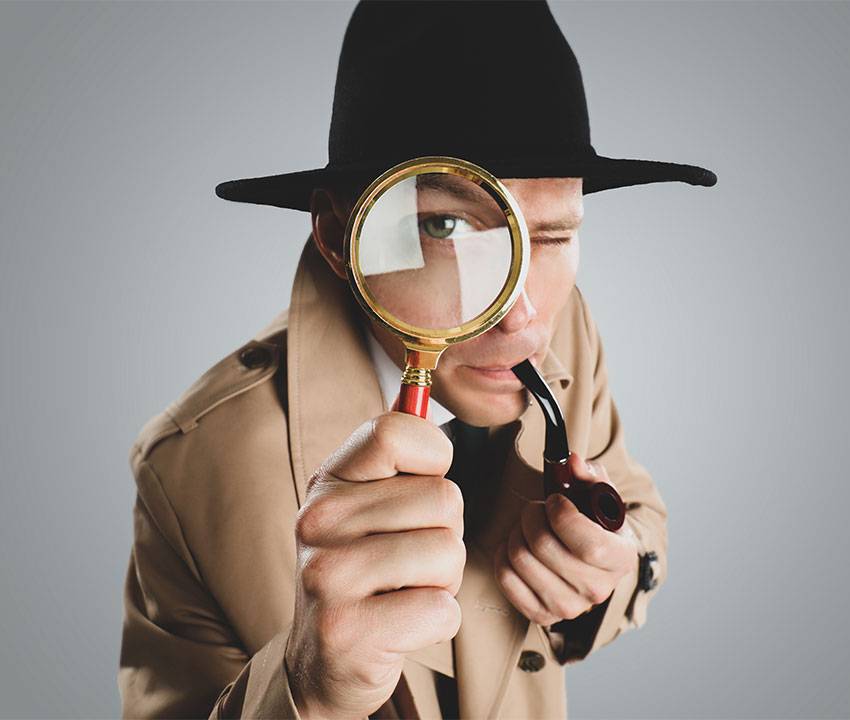 Man in Trench Coat Inspecting with Magnifier