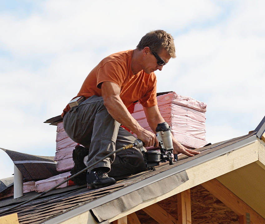 Professional roofer working safely on a roof, using a nail gun to install shingles. Relevant for Texas Contractors and safety grant programs. Professional roofer working safely on a roof, using a nail gun to install shingles. Relevant for Texas Contractors and safety grant programs.