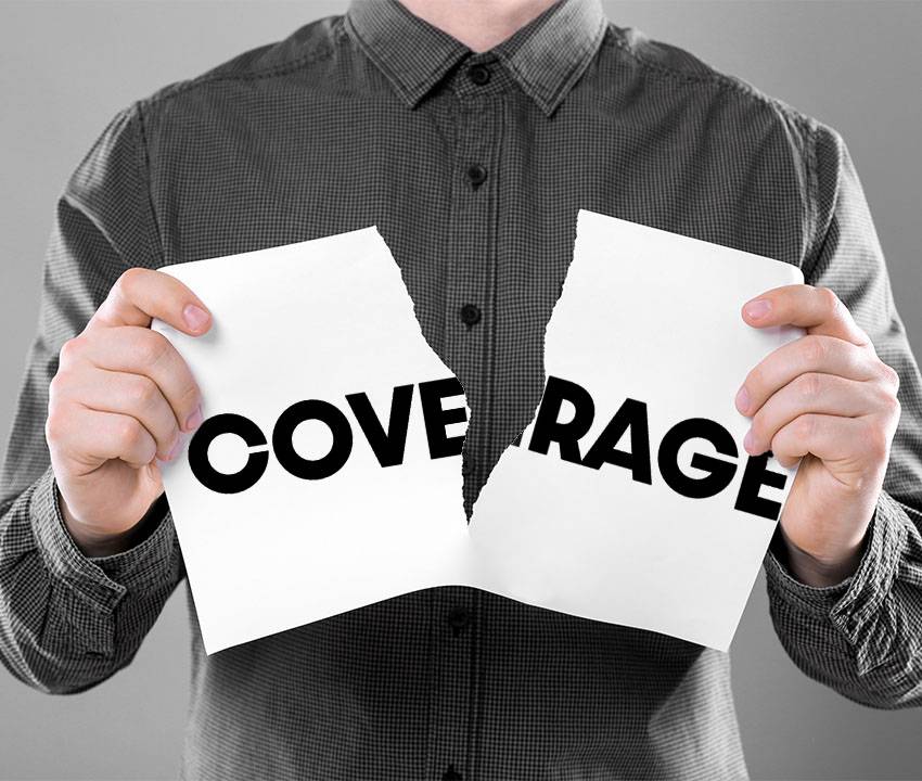 A person holding a torn piece of paper, representing an insurance policy with gutted limits and endorsements.