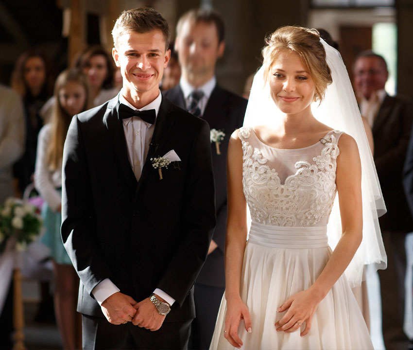 Bride and groom saying vows at wedding ceremony in church
