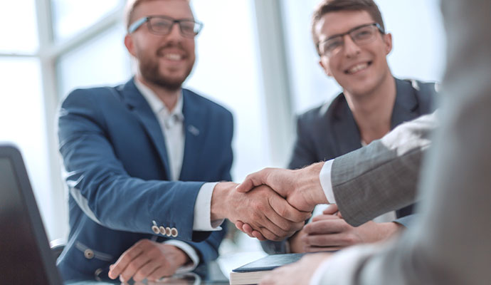 Business partners shaking hands in office