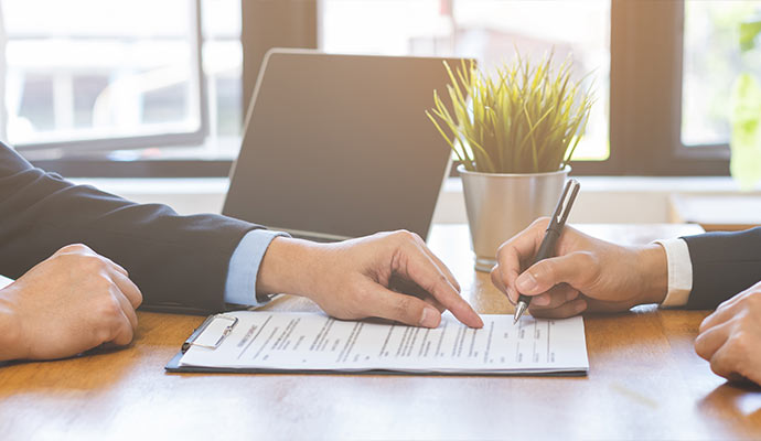 Business person signing commercial insurance document