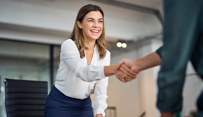 Business professional shaking hands with client in an office
