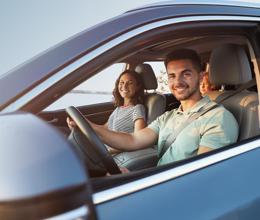 Happy man driving car with his family