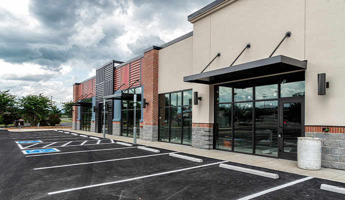 Commercial storefront exterior with parking lot and signage