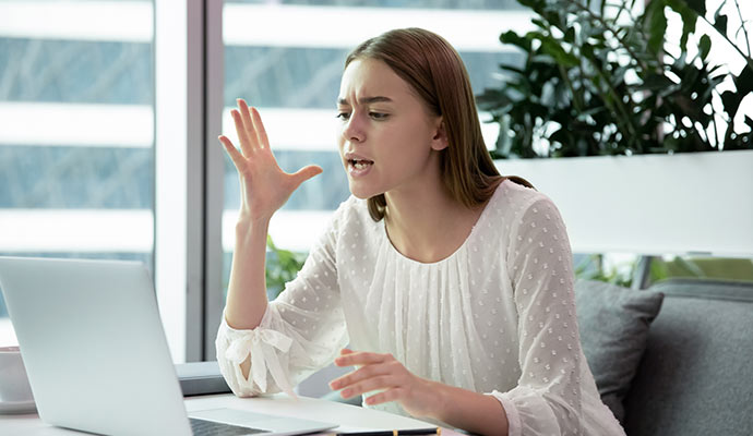 Frustrated woman working on laptop at office