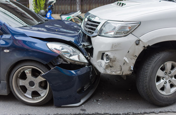 Two men inspecting the damage of their vehicles, which have figured in a collision