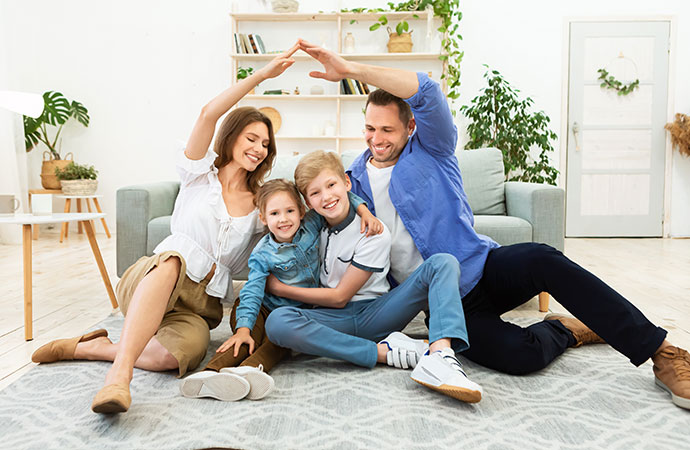 parents making symbolic roof joining hands above kids sitting indoors