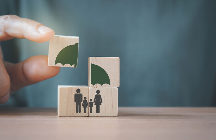umbrella over family icon on wooden cube blocks for life insurance